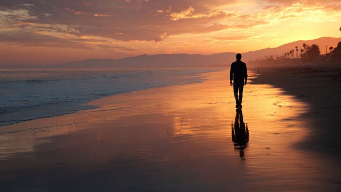 man walking down beach in Santa Barbara at sunset | 2 Years to Transform Life