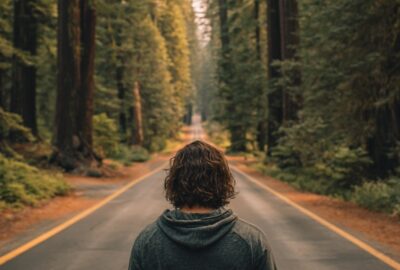 straight line philosophy | young man walking down a road in a Northern California forest