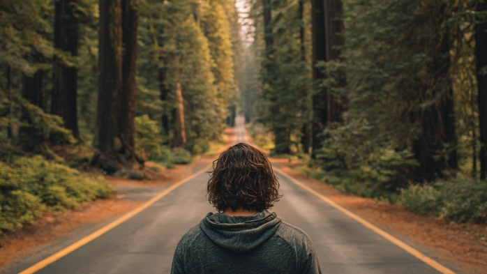 straight line philosophy | young man walking down a road in a Northern California forest